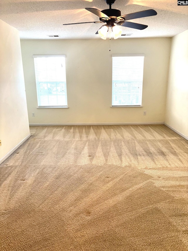 spare room featuring visible vents, carpet flooring, and a textured ceiling