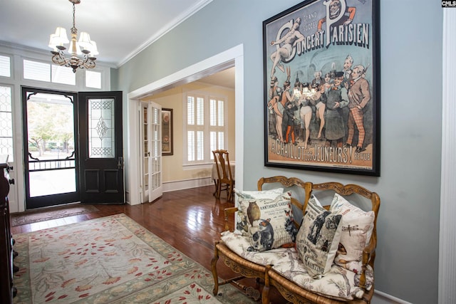 entrance foyer with ornamental molding, dark wood-type flooring, and a chandelier