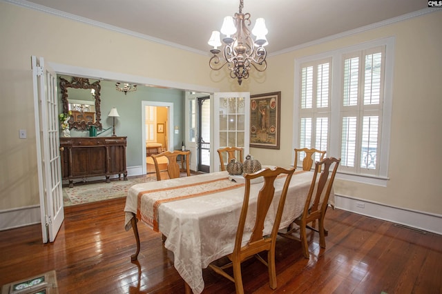 dining area featuring ornamental molding, dark hardwood / wood-style flooring, and an inviting chandelier