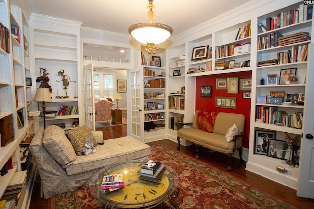 living area with dark wood-type flooring and ornamental molding