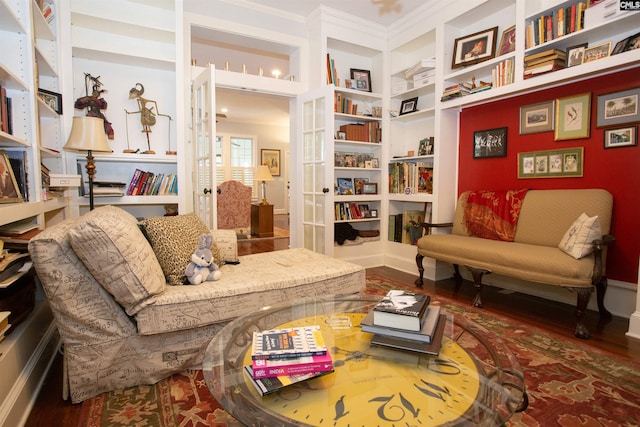 living area featuring ornamental molding, wood-type flooring, and built in features