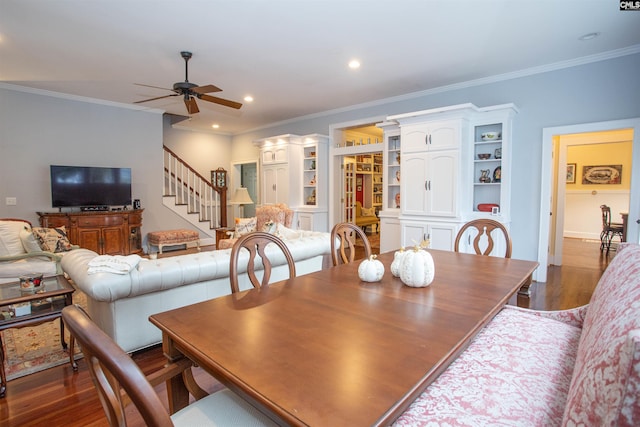 dining room featuring dark wood-type flooring, crown molding, and ceiling fan