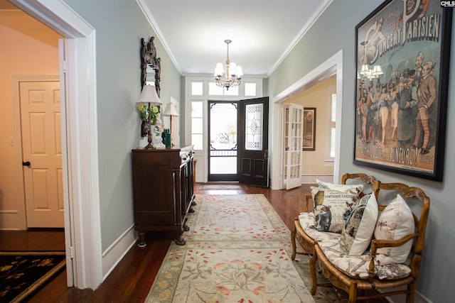 entryway with crown molding, dark hardwood / wood-style floors, and an inviting chandelier