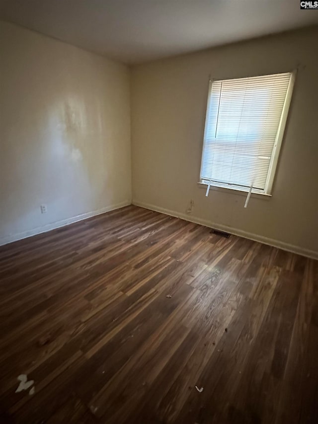 spare room with dark wood-type flooring