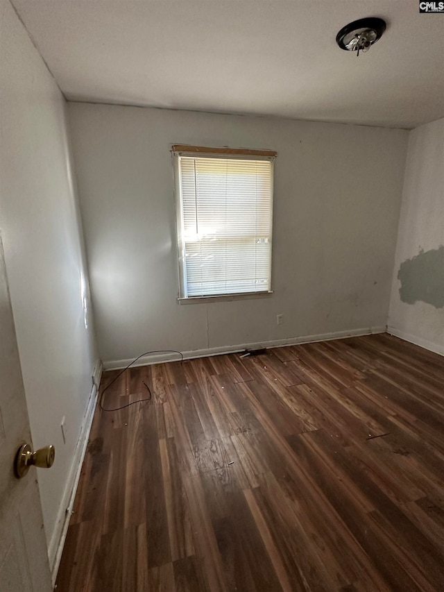 spare room with dark wood-type flooring