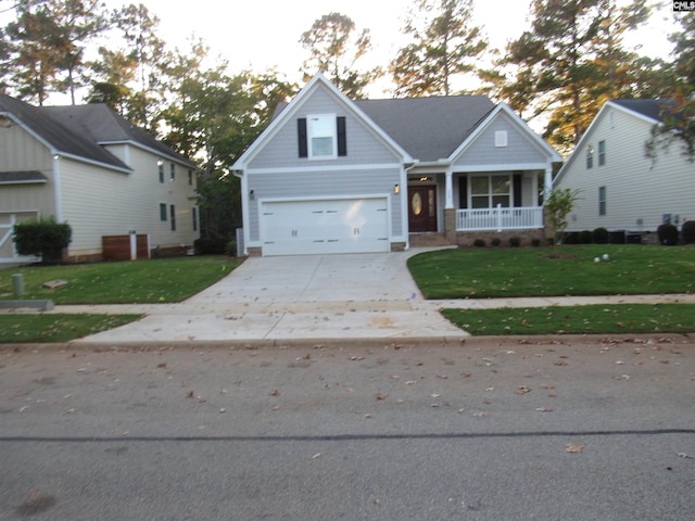 view of front of home with a porch, a garage, and a front lawn