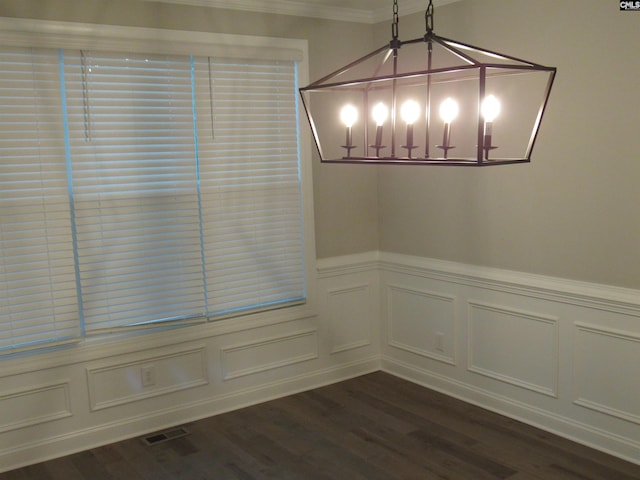 unfurnished dining area featuring crown molding and dark wood-type flooring