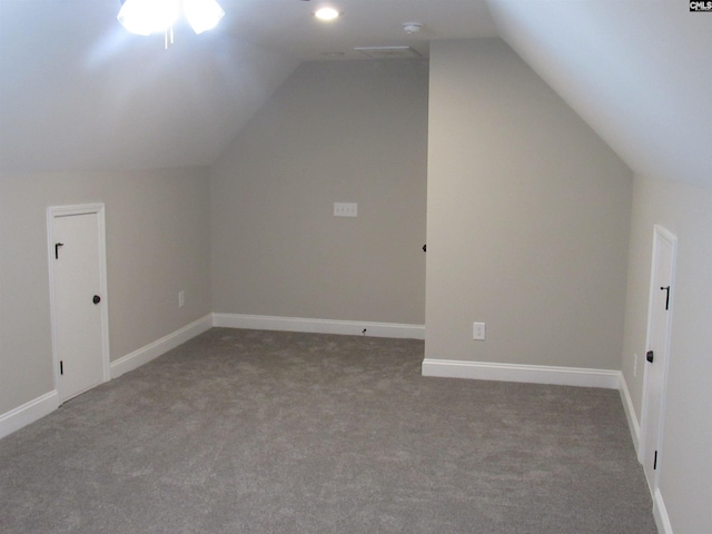 additional living space featuring carpet floors and vaulted ceiling