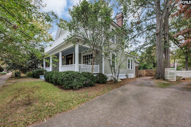 view of front of house featuring covered porch and a front yard