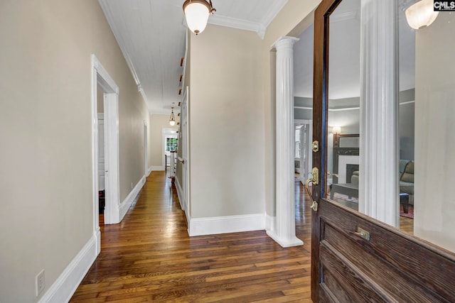 corridor with ornamental molding, ornate columns, and dark hardwood / wood-style flooring