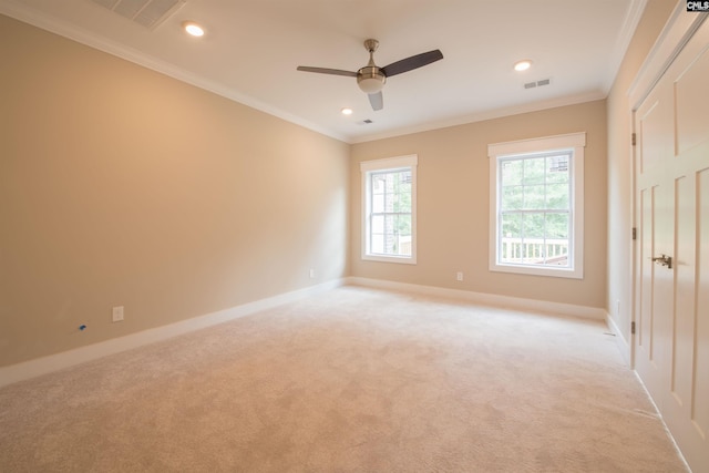 empty room featuring ornamental molding, light colored carpet, and ceiling fan