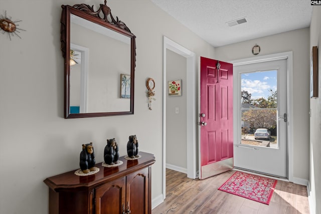 foyer with light hardwood / wood-style floors and a textured ceiling