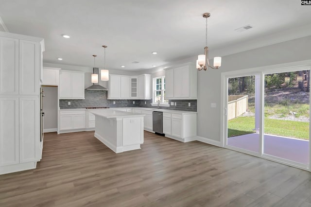 kitchen featuring wall chimney exhaust hood, white cabinetry, and plenty of natural light