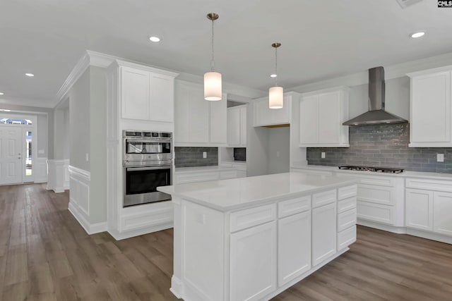 kitchen featuring wall chimney exhaust hood, white cabinets, and stainless steel double oven