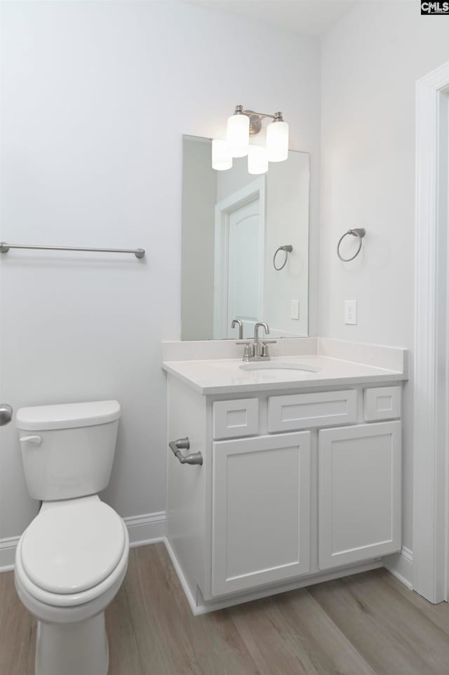 bathroom with vanity, hardwood / wood-style floors, and toilet