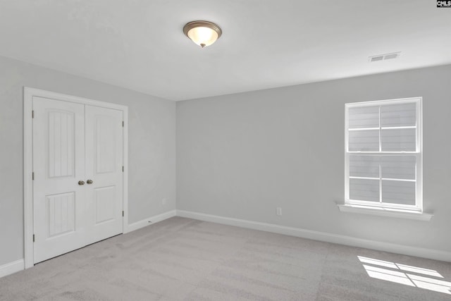 spare room featuring light colored carpet