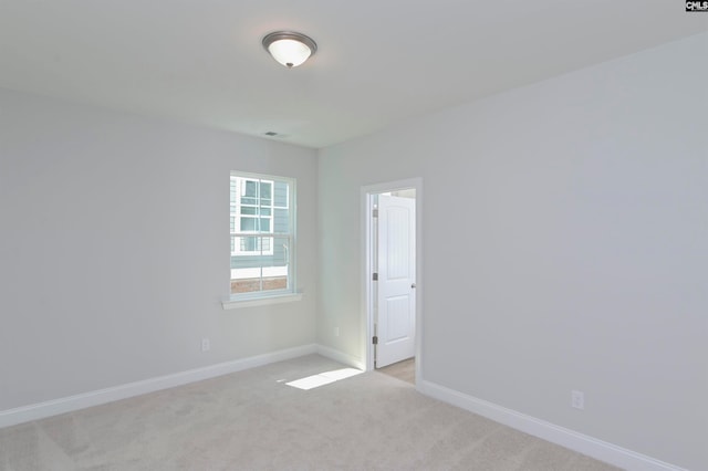 unfurnished room featuring light colored carpet