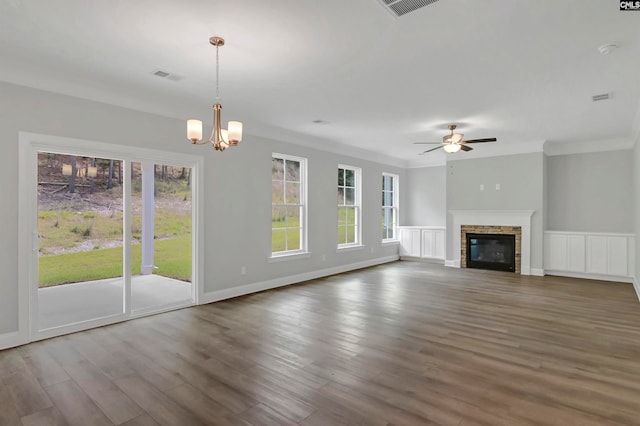 unfurnished living room featuring crown molding, a fireplace, hardwood / wood-style flooring, and a healthy amount of sunlight