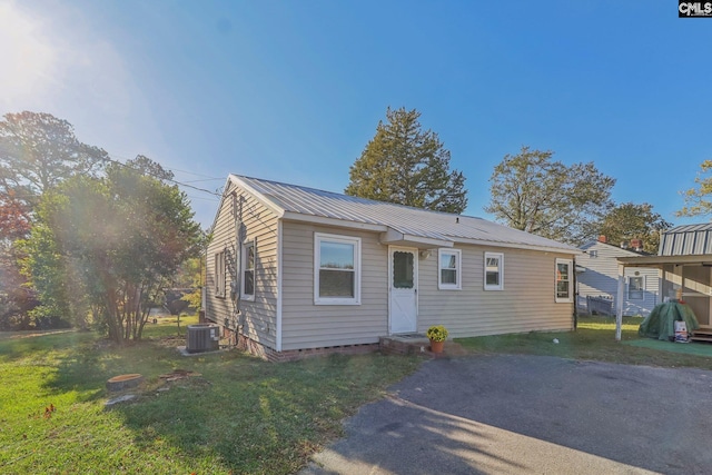 bungalow with a front lawn and central AC unit