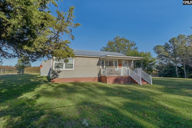 view of front facade with a front yard and covered porch