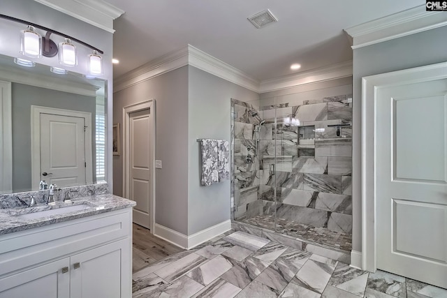 bathroom featuring a tile shower, ornamental molding, and vanity