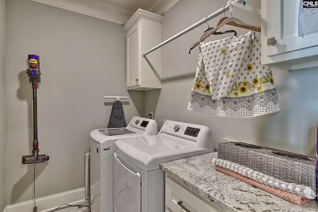 laundry area featuring ornamental molding, washing machine and clothes dryer, and cabinets