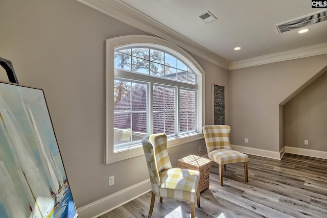 living area with ornamental molding, hardwood / wood-style flooring, and a wealth of natural light