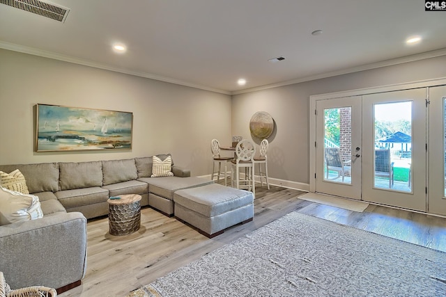 living room featuring french doors, light hardwood / wood-style floors, and ornamental molding