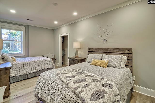 bedroom with ornamental molding and light hardwood / wood-style flooring