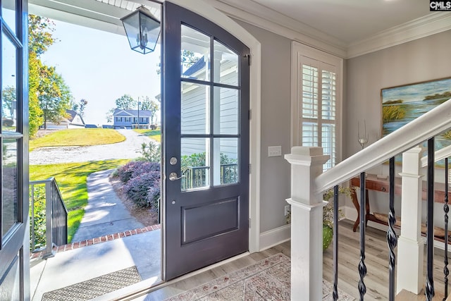 doorway with ornamental molding and light hardwood / wood-style flooring