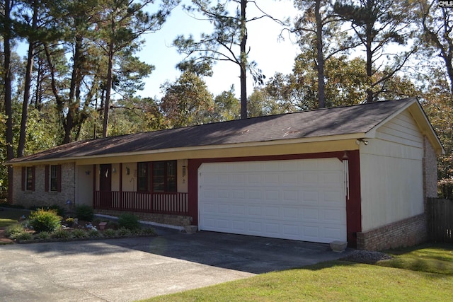 ranch-style home with a porch and a garage