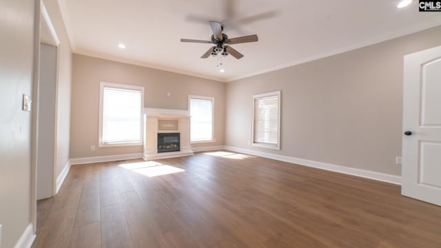 101 Dinkins Place Rd, Blythewood, SC 29130 - unfurnished living room featuring a ceiling fan, wood finished floors, baseboards, crown molding, and a glass covered fireplace