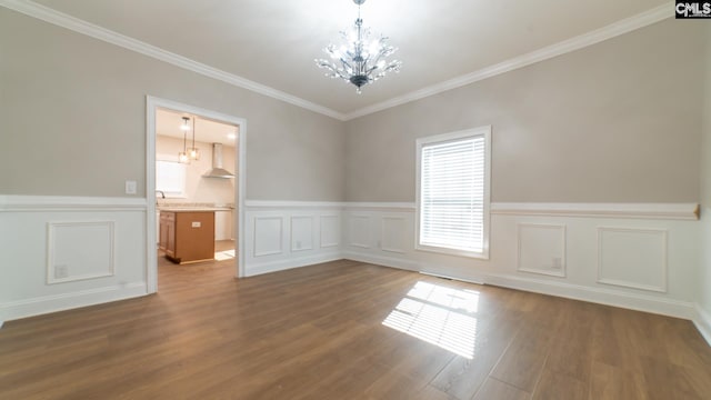 101 Dinkins Place Rd, Blythewood, SC 29130 - empty room featuring a chandelier, wainscoting, wood finished floors, crown molding, and a decorative wall