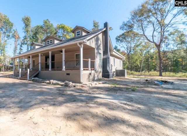 view of side of home featuring ceiling fan, covered porch, and central AC