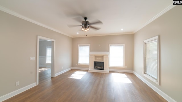 unfurnished living room featuring hardwood / wood-style flooring, ceiling fan, and crown molding