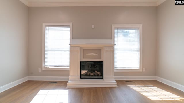 unfurnished living room featuring crown molding and light hardwood / wood-style flooring