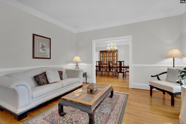 living room featuring ornamental molding, a chandelier, and hardwood / wood-style floors