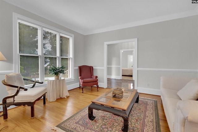 living area with crown molding and light wood-type flooring