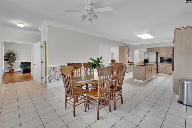 dining space with crown molding, light tile patterned flooring, and ceiling fan