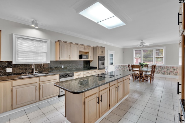 kitchen with black appliances, sink, a center island, ceiling fan, and dark stone counters