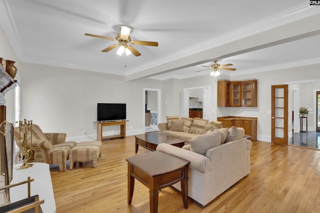 living room featuring ceiling fan, ornamental molding, and light hardwood / wood-style flooring