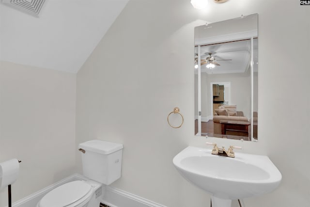 bathroom with lofted ceiling, sink, toilet, and ceiling fan