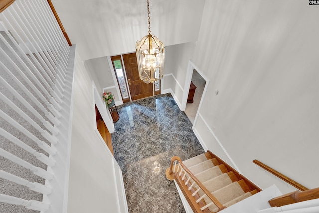 entryway with a towering ceiling and a chandelier