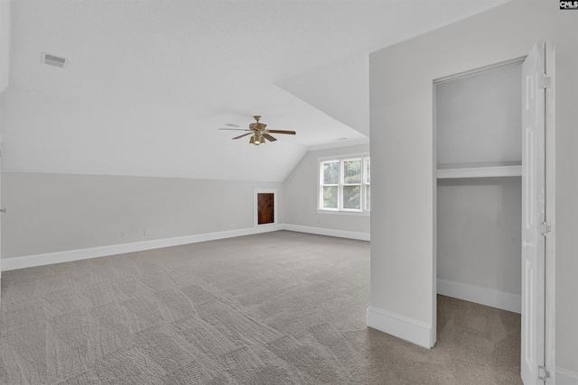 additional living space with vaulted ceiling, carpet floors, and ceiling fan