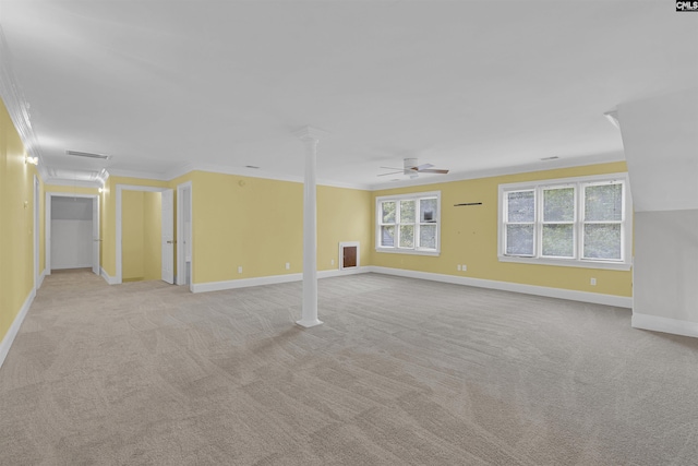 carpeted spare room featuring crown molding, ornate columns, and ceiling fan