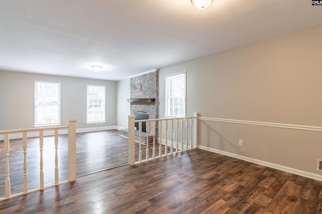 unfurnished living room with dark wood-type flooring and a fireplace