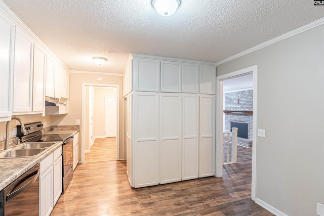 kitchen featuring crown molding, white cabinets, stainless steel appliances, and light hardwood / wood-style floors