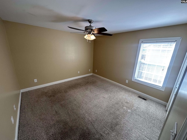 carpeted spare room featuring ceiling fan