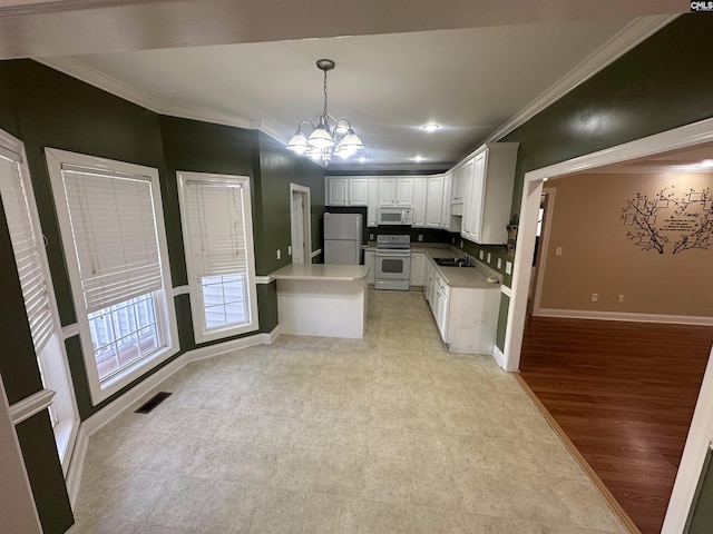 kitchen with white appliances, hanging light fixtures, white cabinetry, light hardwood / wood-style floors, and a chandelier