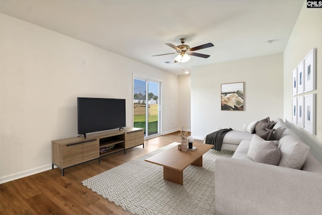 living room featuring ceiling fan and dark hardwood / wood-style flooring